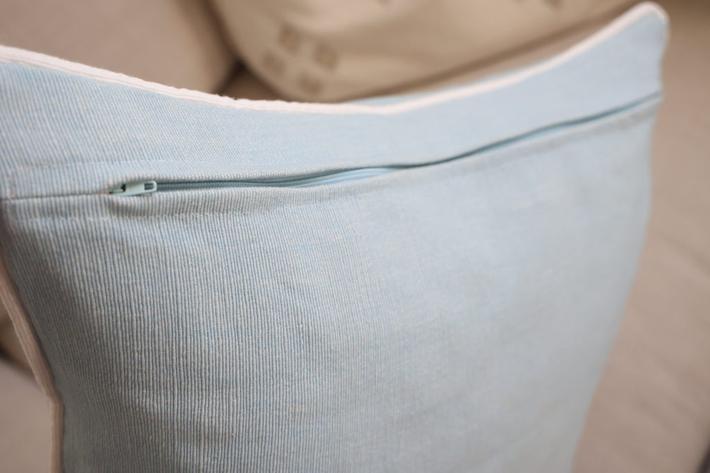 Blue cushion with white piping