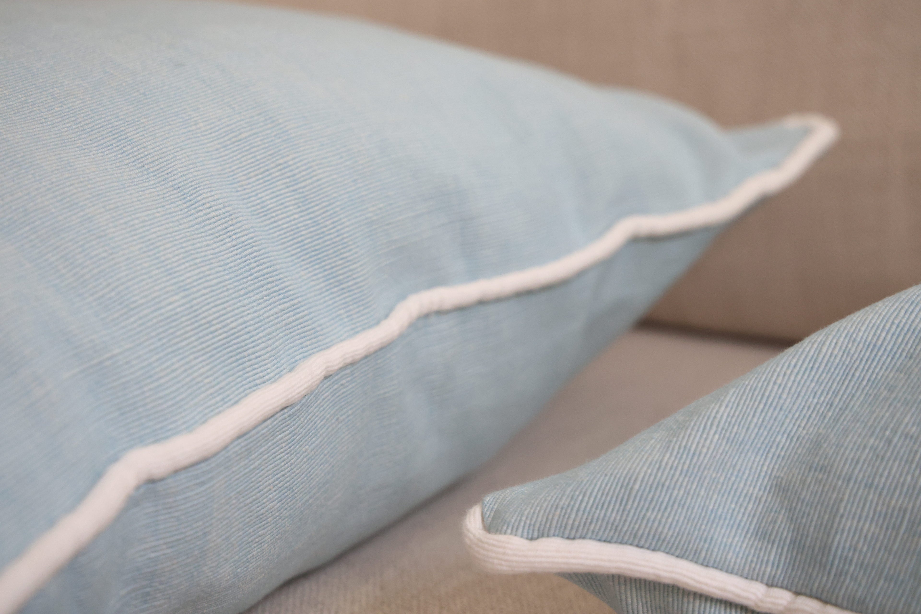 Blue cushion with white piping
