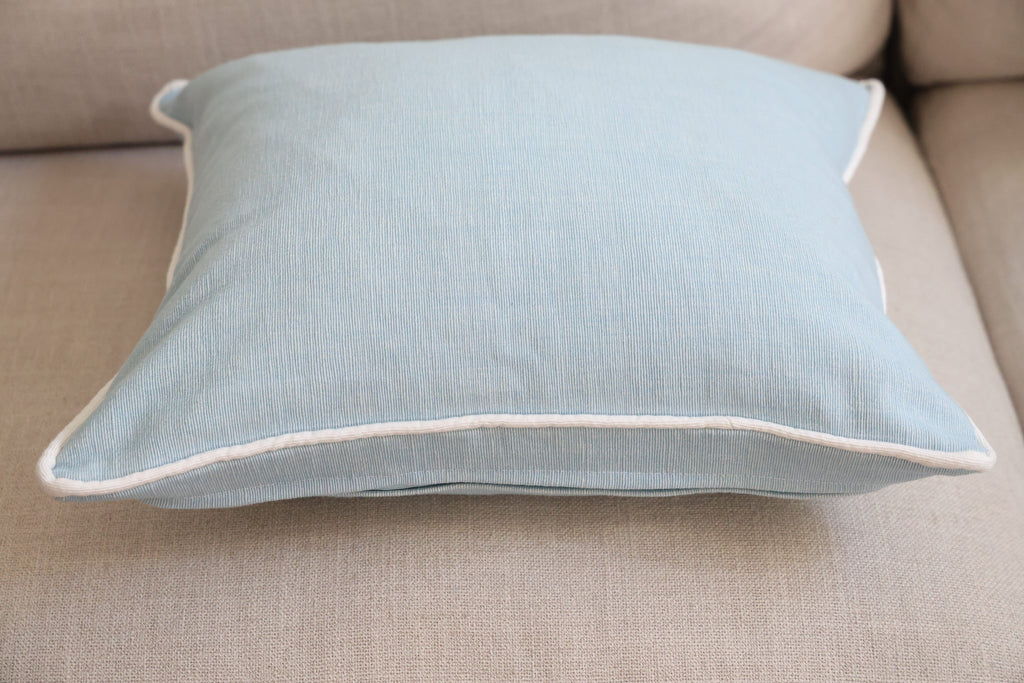 Blue cushion with white piping